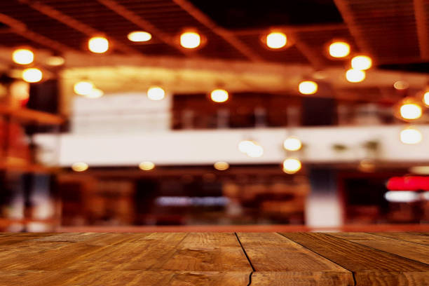 istock Empty wooden table top with blur coffee shop or restaurant interior background 1154647803