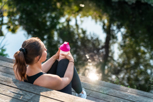 istock Woman resting and drinking a protein shake after her exercise 1154650316