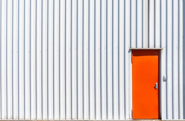 Orange metal door and a white warehouse wall