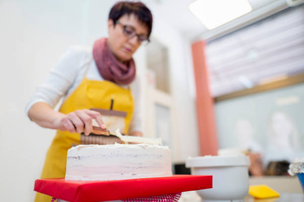 istock Woman working on applying icing on a cake 1154651427