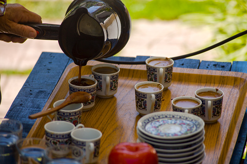 View of outdoor preparation of Turkish Coffee on a wooden table with electric coffee pot