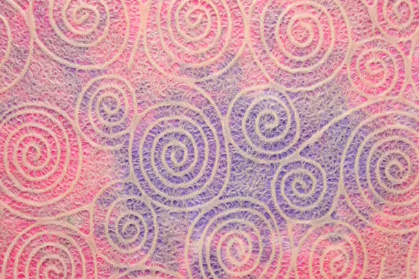 Japanese Washi tissue with white Uzumaki pattern spirals against marbled mulberry paper