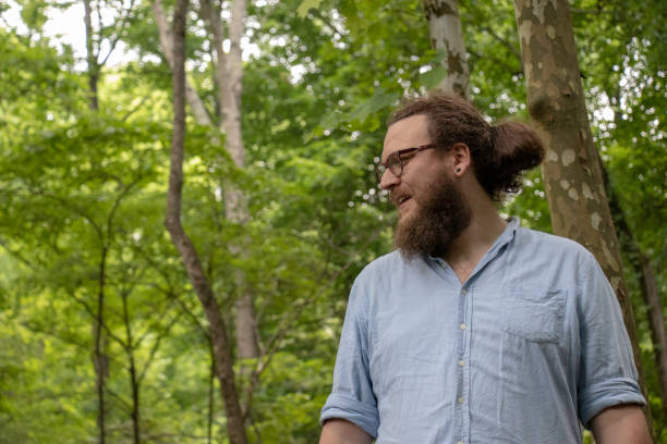 istock Young man looking around in forest is about to smile. 1154663291