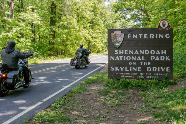 Shenandoah Entry Sign with Motorcycles Shenandoah National Park, United States: May 22, 2015: Motorcyclists enter the Shenandoah National Park to coast along Skyline Drive shenandoah national park photos stock pictures, royalty-free photos & images