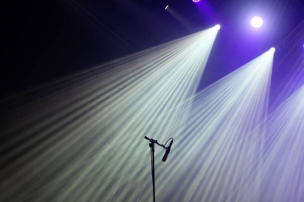 istock Microphone and bright rays of light on stage before the concert begins 1154671278
