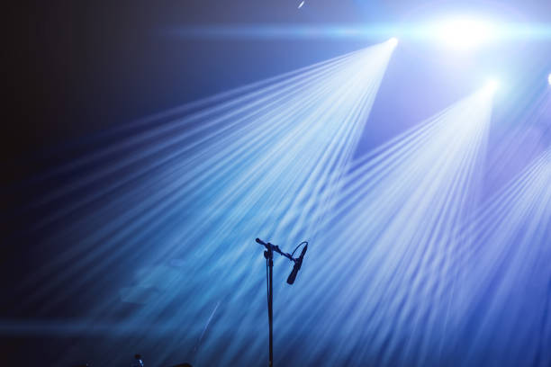 istock Microphone and bright rays of light on stage before the concert begins 1154671281