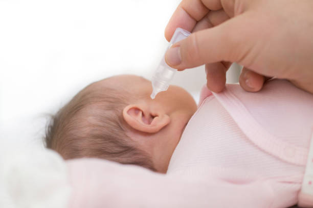 istock mother dribble medication in baby ear. Ear drops 1154676689