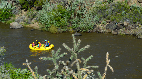 TAOS, NEW MEXICO - MAY 15, 2019: Rafters enjoy floating along the Rio Grande River near Taos, New Mexico. The Rio Grande is one of the principal rivers in the southwest United States and northern Mexico, flowing from Colorado in the U.S. to the Gulf of Mexico.