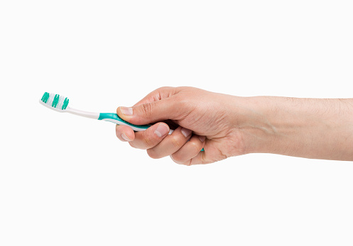 Woman hand holding a toothbrush isolated on a white background