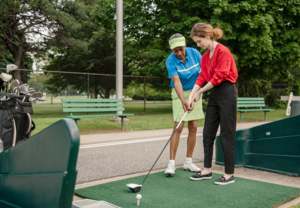 활성 77 년 오래 된 아프리카계 미국인 여자는 골프를 재생 하는 18 세 백인 여자를 가르치고. - 18 19 years happiness cheerful teenager 뉴스 사진 이미지