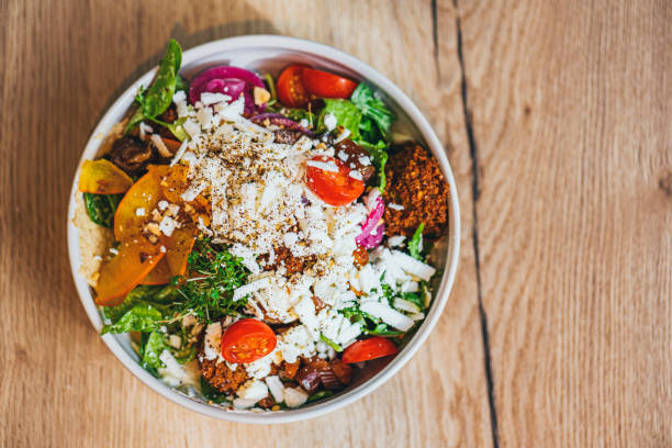 Delicious vegan, gluten free bowls with vegan cheese, chickpea-tofu or falafel and a lot of greens