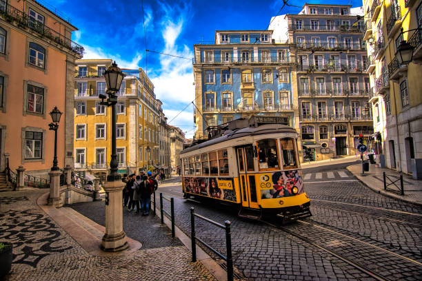 Lisbon, Portugal - January 06, 2018: Photograph of one of the streets of Lisbon. Image made in winter, a period in which the Portuguese capital is much visited by foreigners. In the image we can see some tourists waiting for the right moment of the tram to pass to take a \
