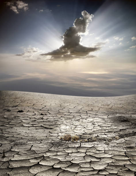 istock dried and cracked empty landscape over cloudy sky with sunbeam 1154689334
