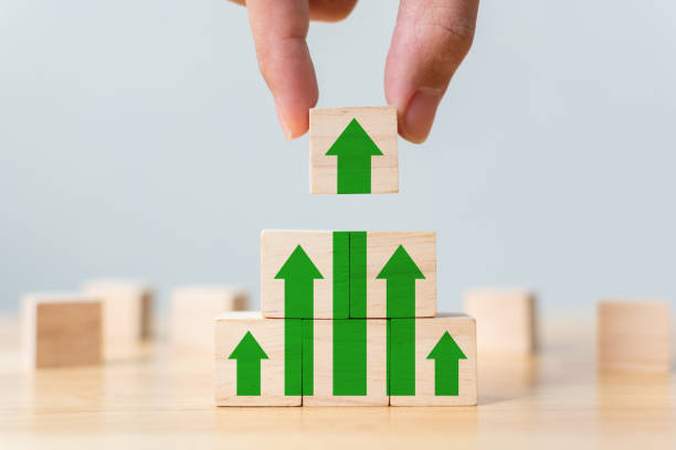 istock Ladder career path for business growth success process concept. Wood block stacking as step stair with arrow up. Hand putting wooden cube block on top pyramid 1154691032