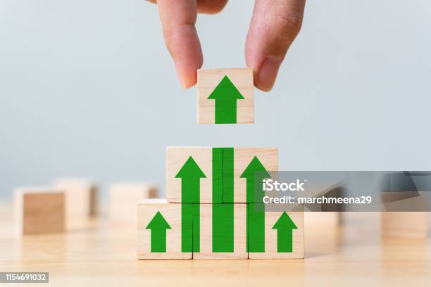 Ladder Career Path For Business Growth Success Process Concept Wood Block Stacking As Step Stair With Arrow Up Hand Putting Wooden Cube Block On Top Pyramid Stock Photo - Download Image Now