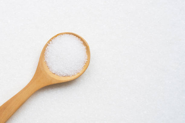 istock Wooden spoon with white granulated sugar. 1154692773