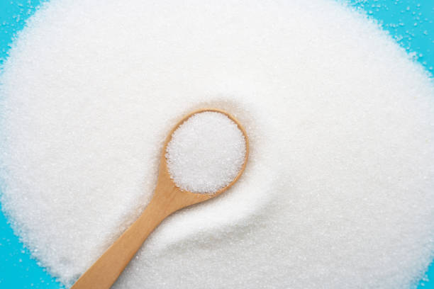 istock Wooden spoon with white granulated sugar on blue background. 1154692778