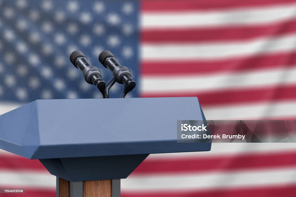 Flag of the United States at a press conference with microphones Podium lectern with two microphones and United States flag in background Debate Stock Photo