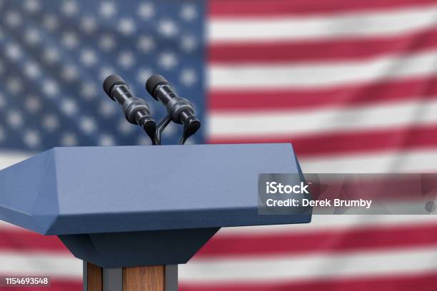 Flag Of The United States At A Press Conference With Microphones Stock Photo - Download Image Now