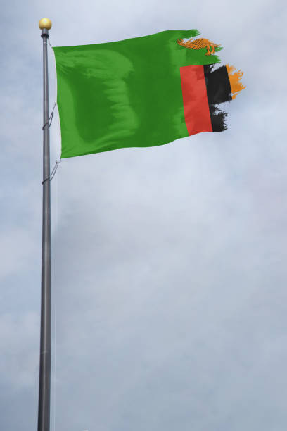 Flag of Zambia with a torn edge, in front of a stormy sky Worn and tattered Zambia flag blowing in the wind on a cloudy day zambia flag stock pictures, royalty-free photos & images