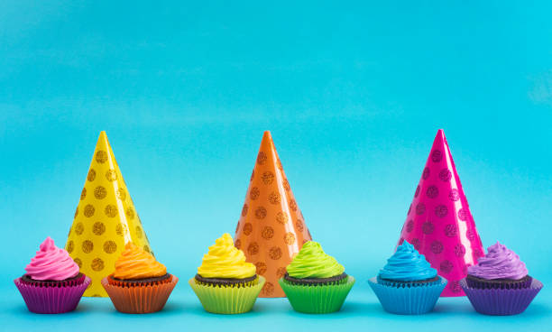istock Rainbow Colored Frosted Chocolate Cupcakes on a Teal Background 1154695930