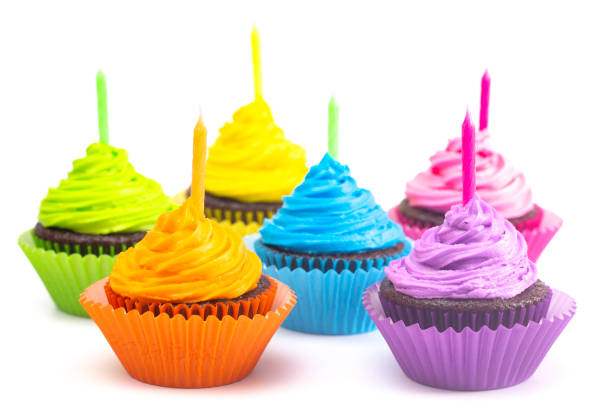 istock Rainbow Colored Frosted Chocolate Cupcakes Isolated on a White Background 1154696003
