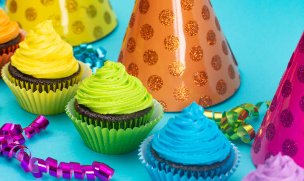 радуга цветные замороженные шоколадные кексы на фоне чир - party hat hat variation isolated стоковые фото и изображения