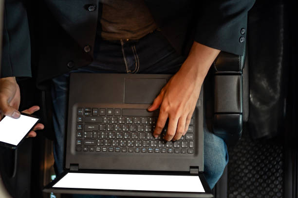 istock Young businessman using mobile phone and laptop in car 1154696685