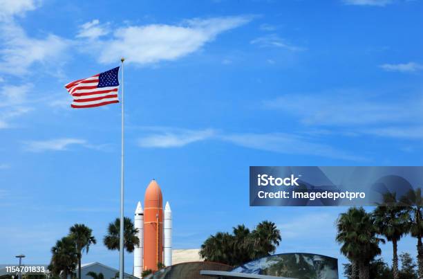 Waving American Flag At Kennedy Space Center With Space Rocket Stock Photo - Download Image Now