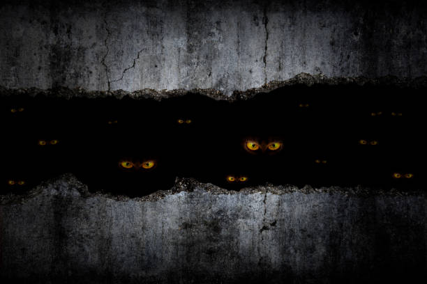 Scary eyes in damaged grungy crack and broken concrete wall and the dark Scary eyes in damaged grungy crack and broken concrete wall and the dark Halloween creepy glowing eyes stock pictures, royalty-free photos & images