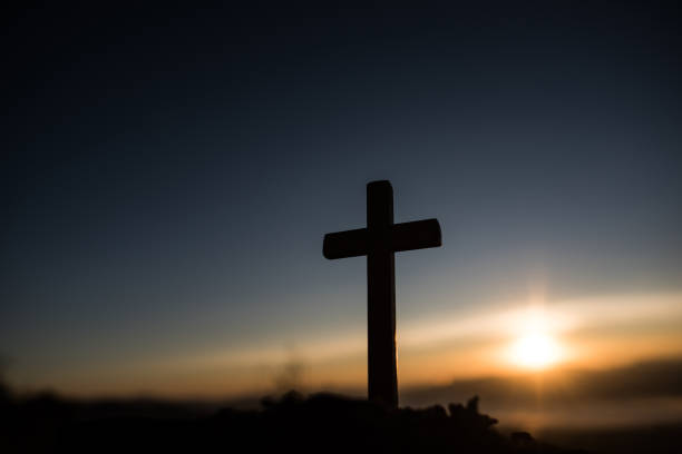 istock Silhouette of catholic cross and sunrise 1154702520