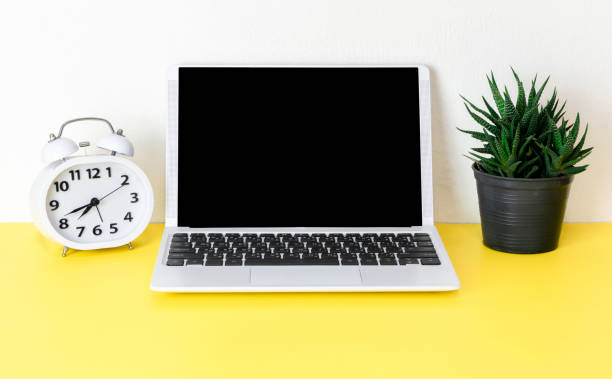 istock Laptop placed on a yellow table background of business working place with cup coffee, Empty workspace 1154705121