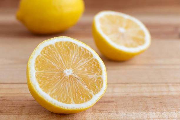 istock Fresh yellow lemon and half a lemon on a wooden table. 1154710804
