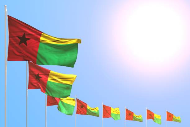 istock cute feast flag 3d illustration
 - many Guinea-Bissau flags placed diagonal on blue sky with space for text 1154712078