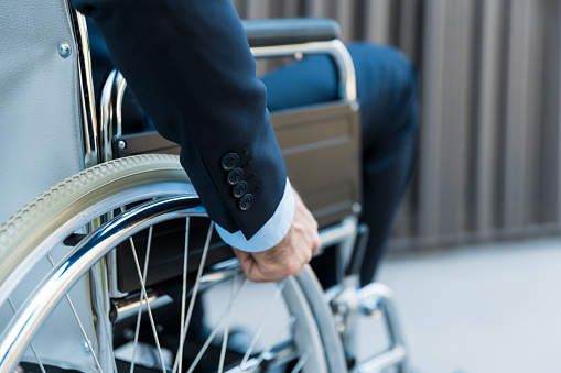 Close up photograph of businessman hand driving wheelchair
