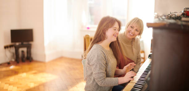 mother and daughter playing piano playing the piano at home girl playing piano stock pictures, royalty-free photos & images