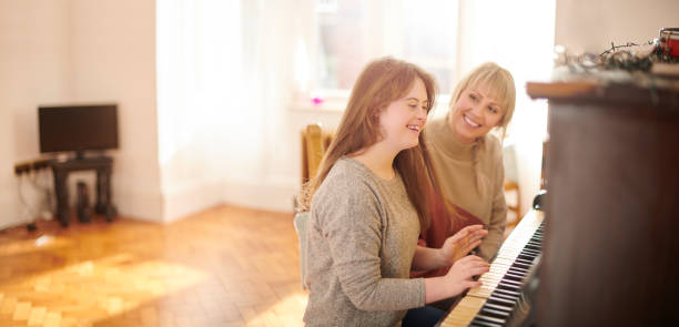 mother and daughter playing piano - practicing piano child playing imagens e fotografias de stock