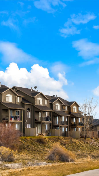 istock Vertical frame Houses with balconies and arched windows against blue sky with puffy clouds 1154715138
