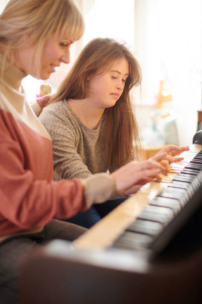 istock mother teaching daughter piano 1154715181