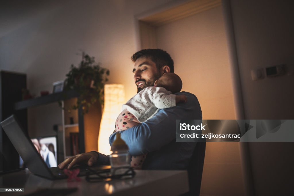 Young father working at home with his baby  girl Father Stock Photo