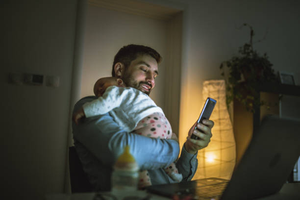 junger vater arbeitet zu hause mit seinem baby mädchen - multitasking fotos stock-fotos und bilder