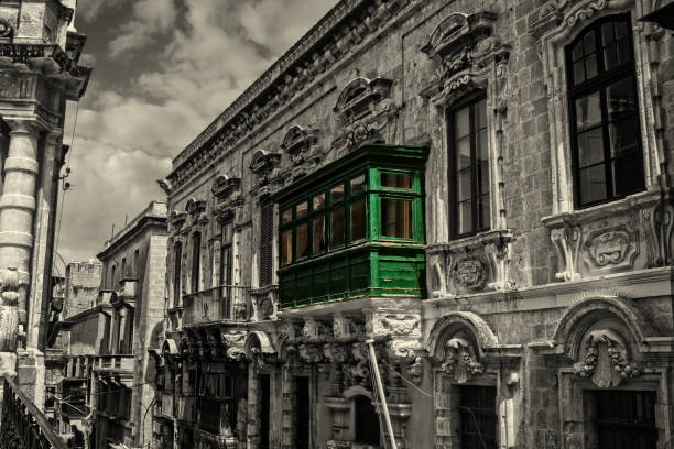 A classical vintage wooden balcony in Valletta, Malta in a narrow historical road in black and white.