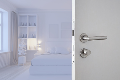 Door handle , door open in front of white blur bedroom luxury interior room background, selective focus