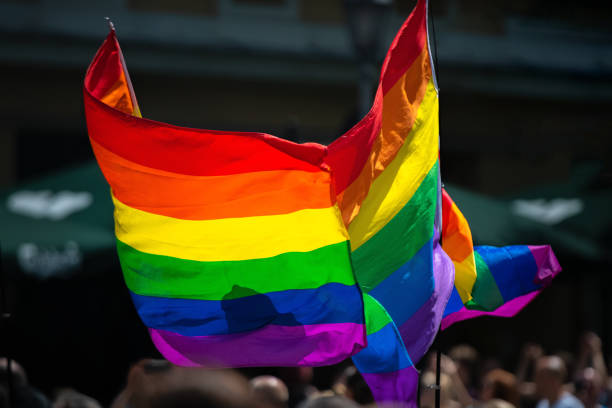 istock Rainbow flag supporting LGBT community on gay parade event. Colourful flag in the crowd during gay pride celebration 1154720522