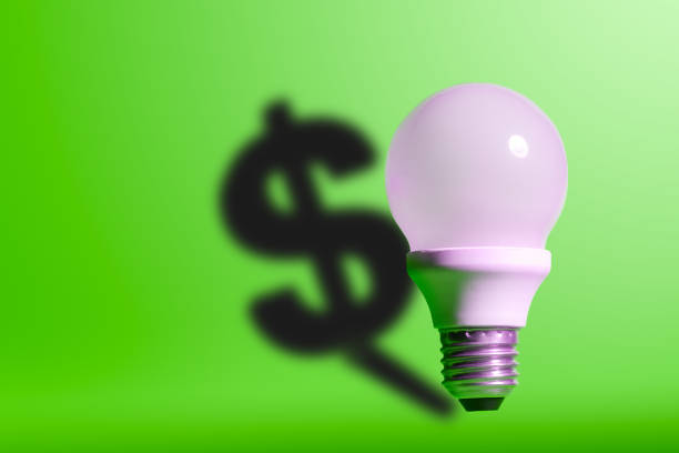 istock Light bulb on bright green background with a dollar sign shadow. Conception good idea it's money. 1154721429