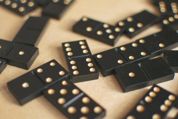 istock black dominoes on light wooden background 1154725820