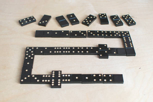 istock black dominoes on light wooden background 1154725891