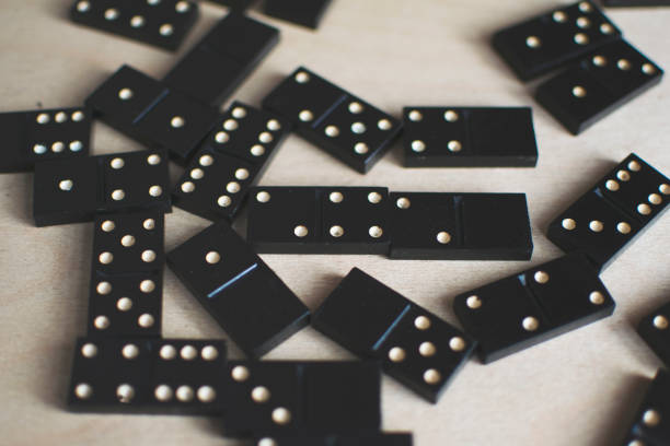 istock black dominoes on light wooden background 1154725908