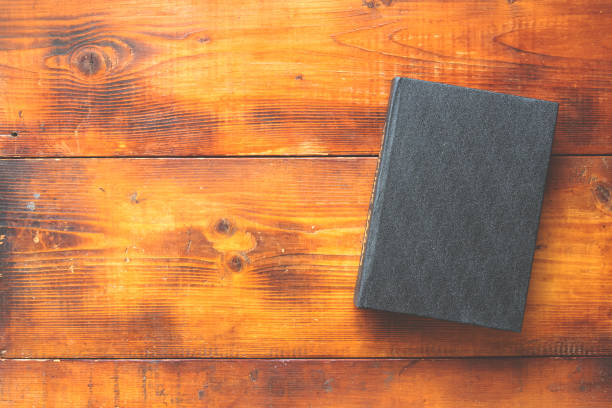 istock old book with black cover on a wooden background 1154728378