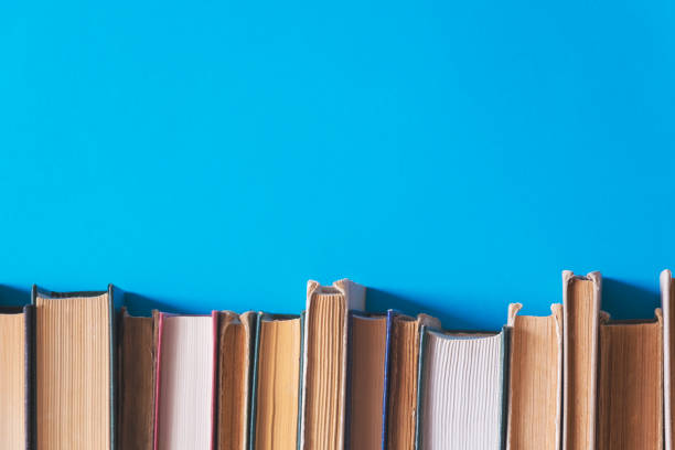 alte bücher auf bücherregalen mit blauem hintergrund - book book spine in a row library stock-fotos und bilder